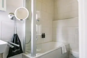 HENRI GAP Petit Kabinett Ein Badezimmer mit Dusche und Badewanne.