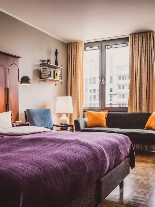 Schlafzimmer mit lila Bett und Couch.