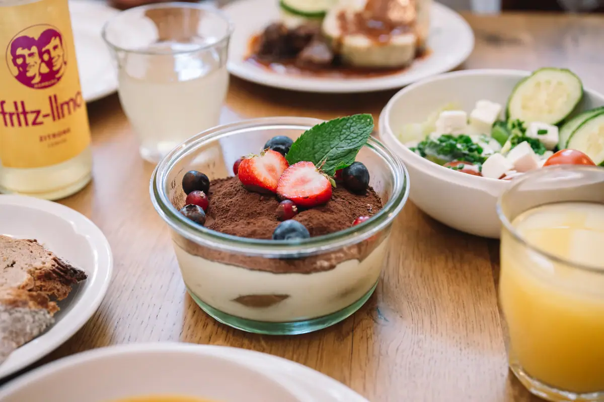 Schale mit Dessert, garniert mit Erdbeeren und Blaubeeren.