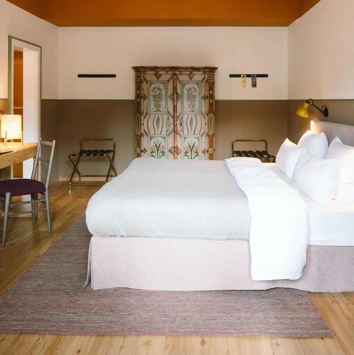 Ein schönes Hotelzimmer im HENRI Garmisch-Partenkirchen mit einem Bett und einem Schreibtisch.