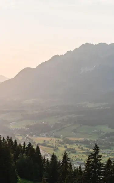 Jetzt buchen & genießen. Ein Wanderweg führt zu einem See inmitten einer natürlichen Landschaft in den Bergen..