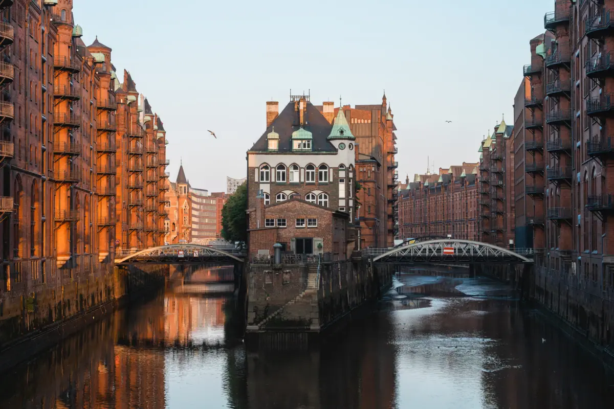 Fluss mit Gebäuden und einer Brücke im Vordergrund.