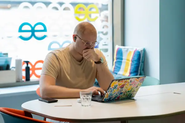 Ein Mann sitzt an einem Tisch und stützt sein Gesicht mit der Hand.