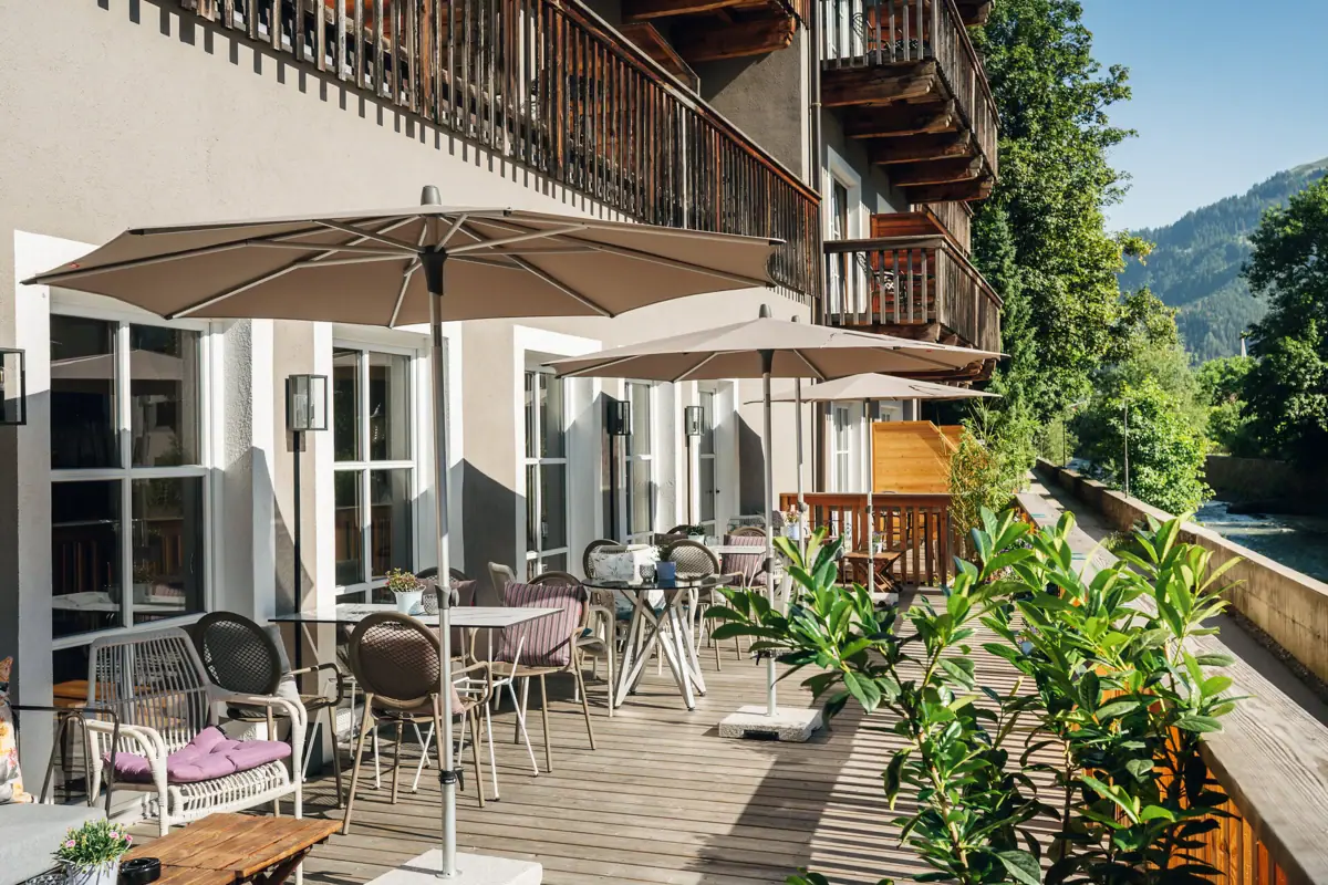 Terrasse mit Stühlen und Sonnenschirmen auf einem Deck