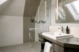 Badezimmer im HENRI Garmisch-Partenkirchen Badezimmer mit Dusche und Waschbecken