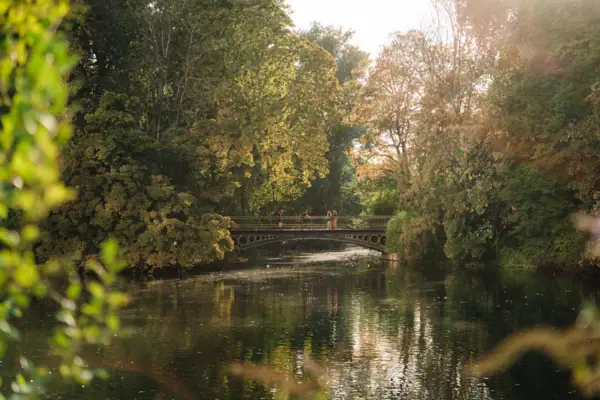 Brücke über ein Gewässer mit Bäumen im Herbst.