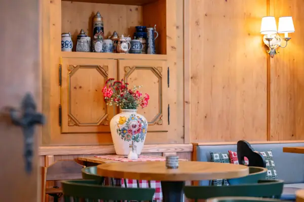 Ein Tisch mit einer Vase voller Blumen darauf.