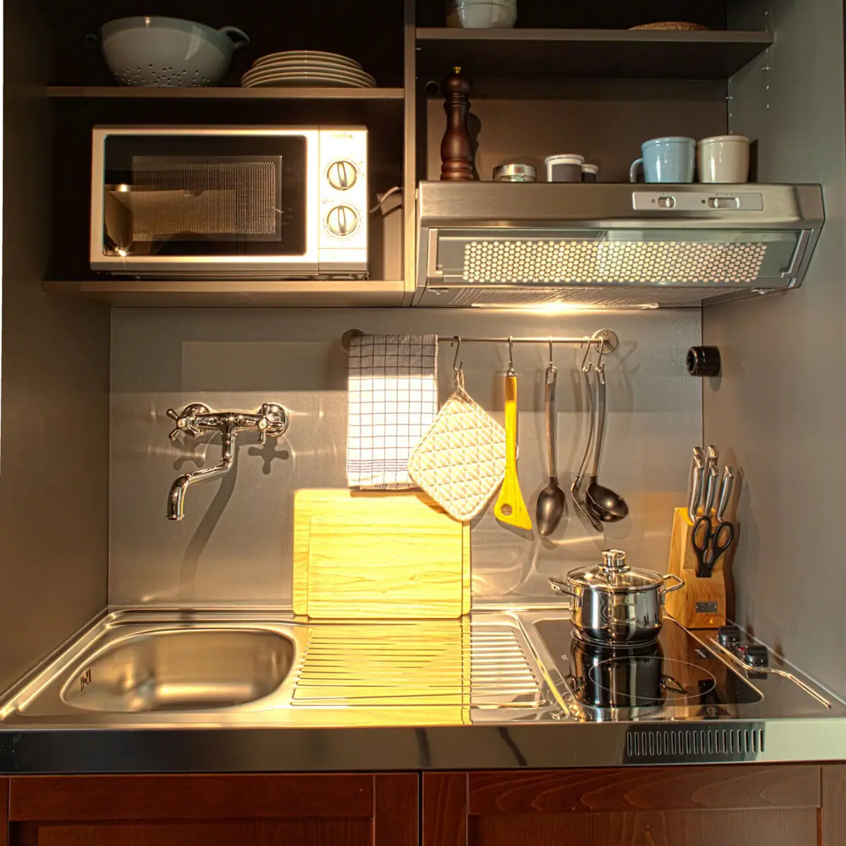 Kleine Kücheninsel mit Spüle, zwei Kochfeldern und Mikrowelle