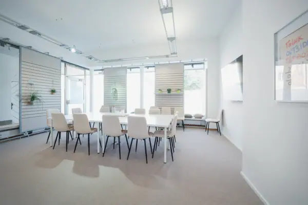 Ein Zimmer mit einem Tisch und Stühlen.