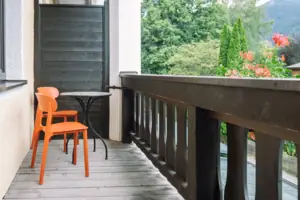 Balkon im Chambre im HENRI Garmisch-Partenkirchen Ein Tisch und Stühle auf einem Deck.