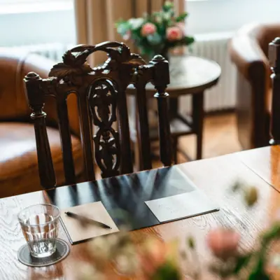 Holztisch mit Stühlen und Meetingunterlagen