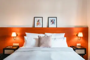 Bett mit weißer Decke und rotem Kopfteil