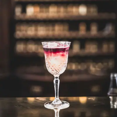 Ein Glas mit Getränk auf einer Bar.