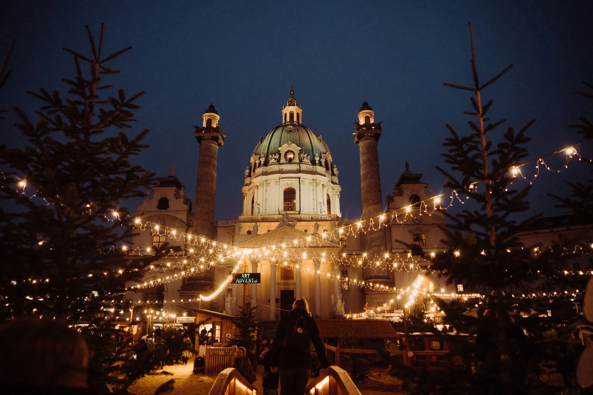Ein beleuchtetes Gebäude mit Kuppel bei Nacht.