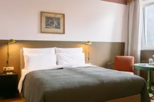 Zimmer und Bett Ein Bett mit Kissen und einer Lampe in einem Zimmer.