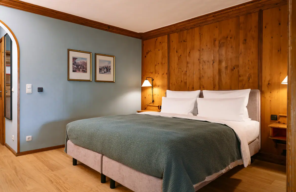 Ein Bett mit holzgetäfelter Wand und Lampe.