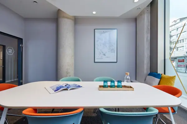 Ein Tisch mit blauen Stühlen und einem Buch darauf.