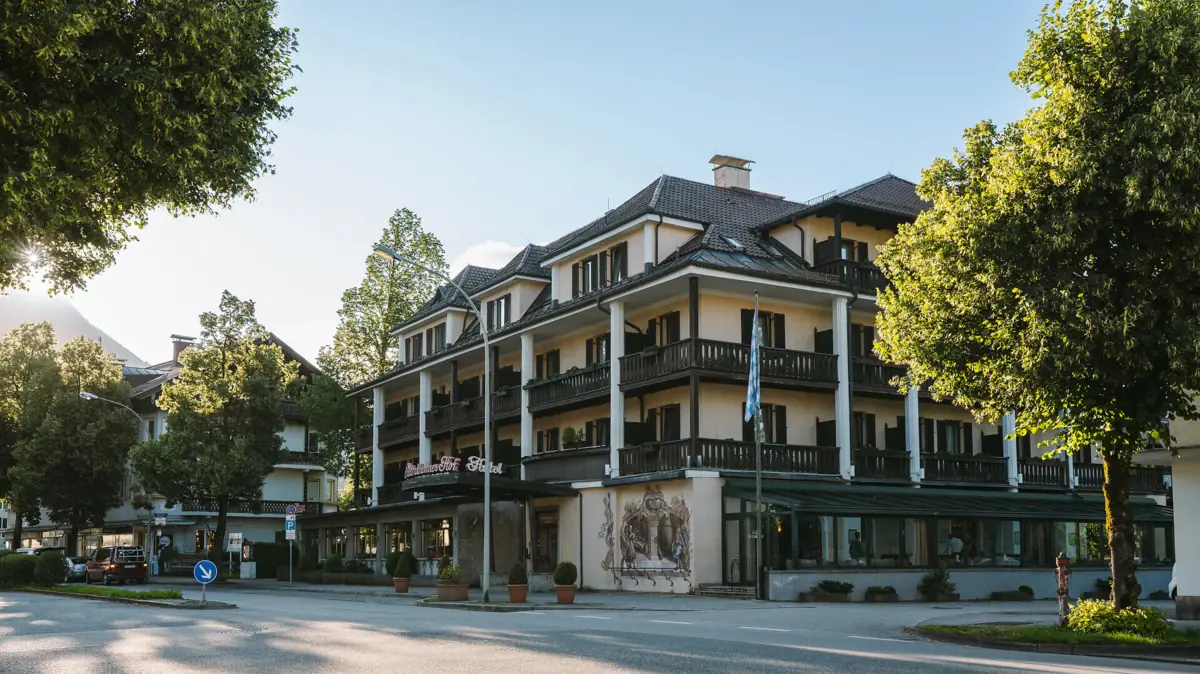 Die Außenansicht HENRI Hotel Garmisch-Partenkirchen von Bäumen umgeben.