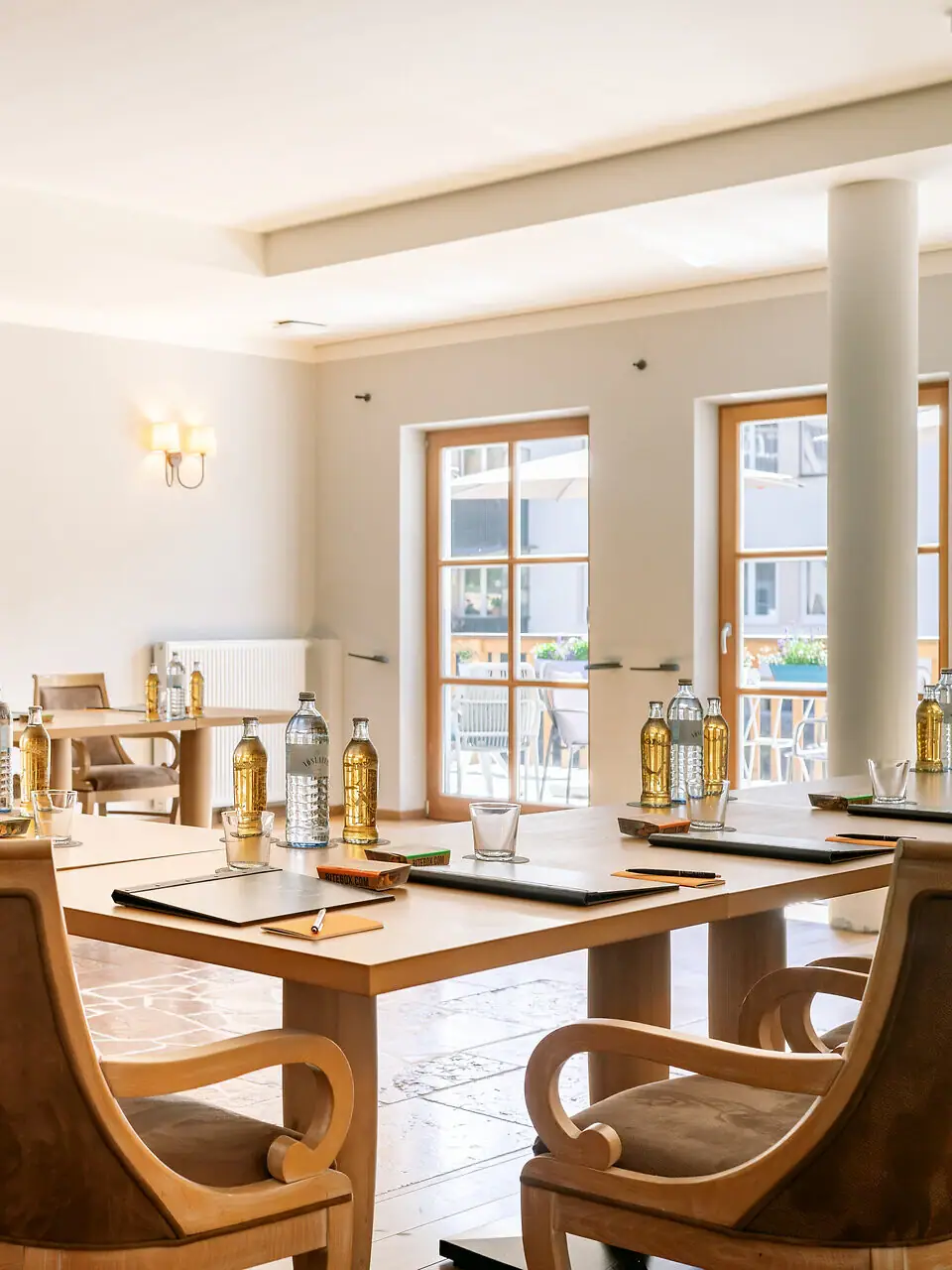 Ein heller Tagungsaum mit Tischen und Stühlen.