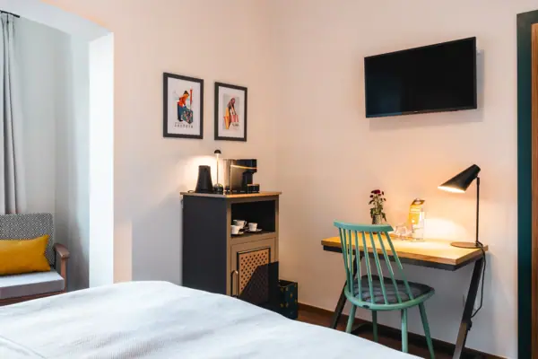 Ein Zimmer mit Bett, Schreibtisch und Fernseher.