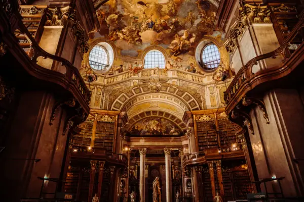 Eine große, verzierte Bibliothek mit einem Deckenfresko.