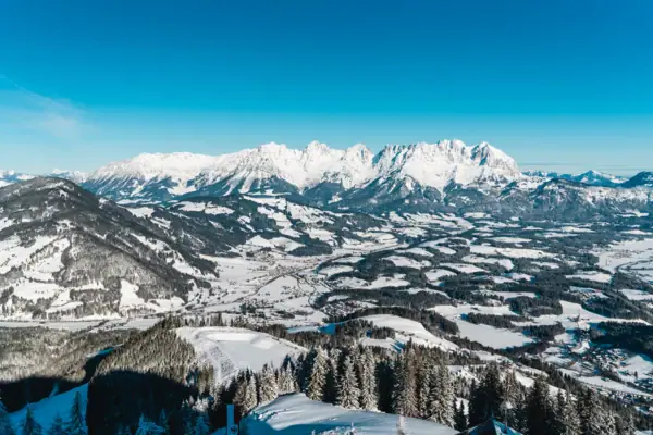 Verschneite Berge und ein Tal in einer winterlichen Landschaft.