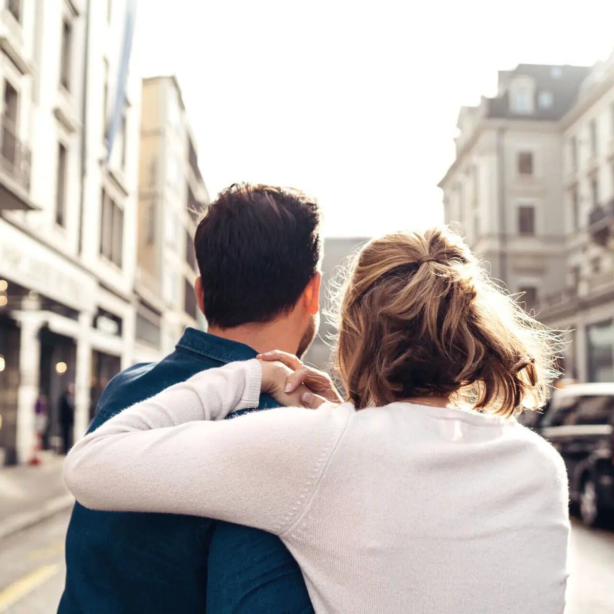 Hochzeiten im HENRI Ein Mann und eine Frau umarmen sich auf einer Straße.