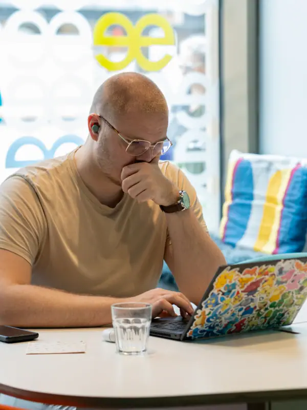 Ein Mann sitzt an einem Tisch und stützt sein Gesicht mit der Hand.