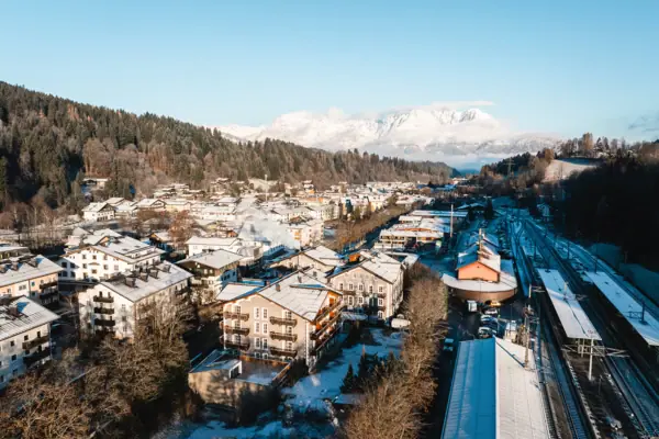 Eine verschneite Stadt im Winter mit Bergen im Hintergrund.