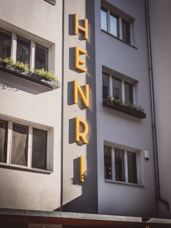 Fassade des HENRI Hotels Wien Ein Gebäude mit einem Schild an der Seite.