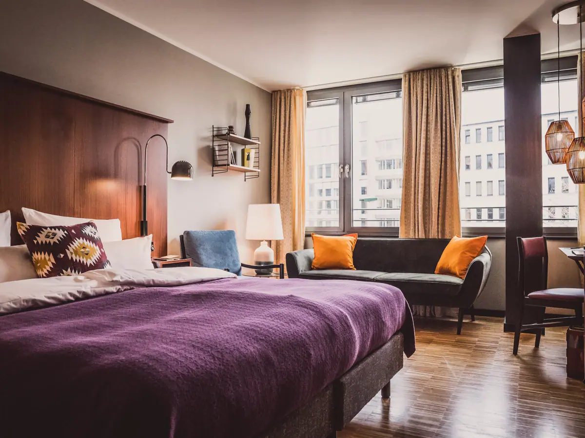 Schlafzimmer mit lila Bett und Couch.