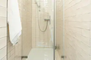 Dusche mit Glastür und Fliesen.