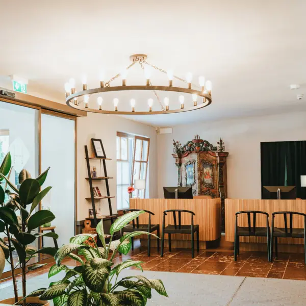 Ein Zimmer mit einem Kronleuchter und Stühlen.