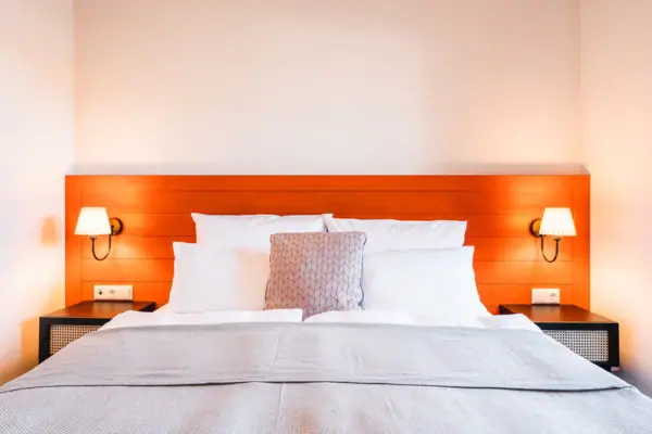 Ein Bett mit Kissen und einer Lampe auf dem Nachttisch.