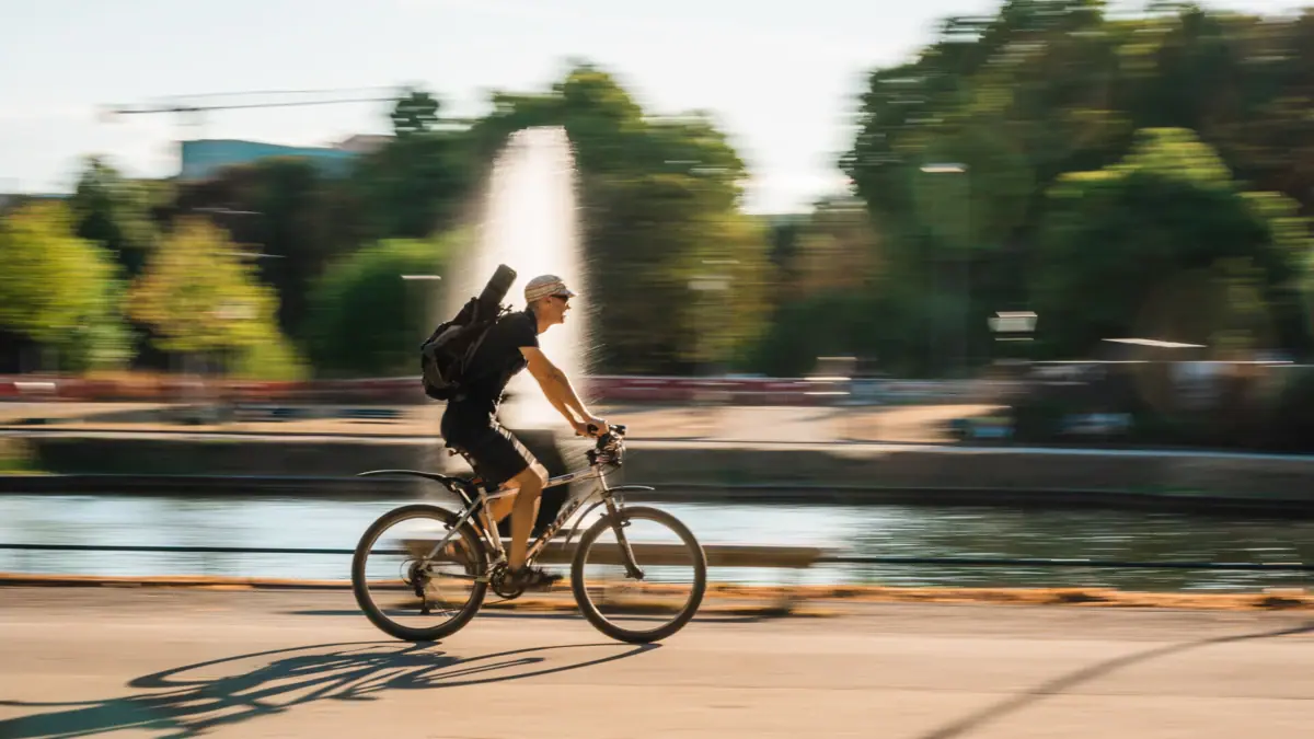 Ein Mann fährt mit einem Rucksack auf einem Fahrrad.