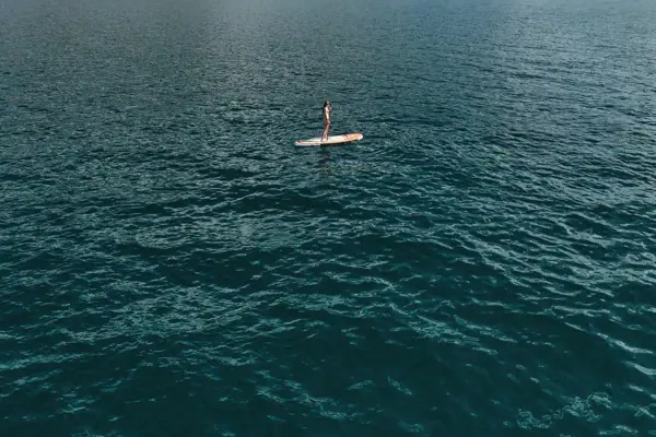 Person auf einem Paddleboard auf einem See.