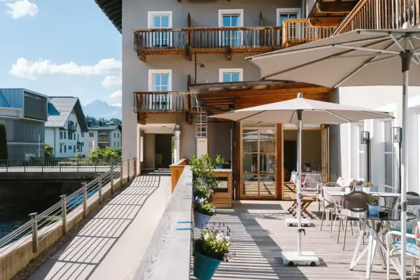 Eine Terrasse mit Stühlen und Sonnenschirmen auf einem Deck.
