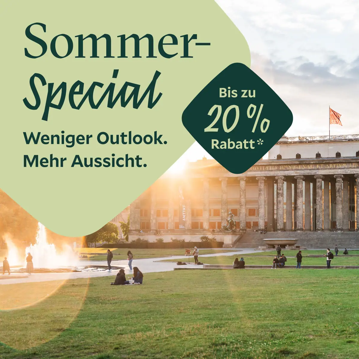 Eine Gruppe von Menschen auf einer Wiese mit einem Brunnen vor einem Gebäude.