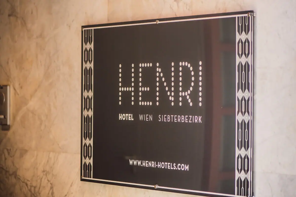 Ein rechteckiges Schild mit Text an einer Wand.